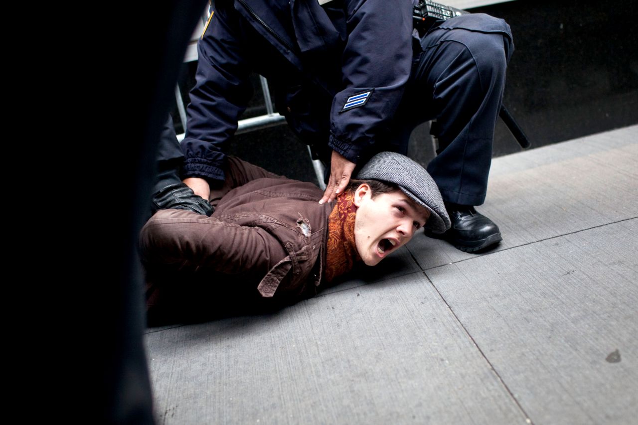 Police oficers arrest a protester in the Financial District. Scores were arrested Thursday in New York.