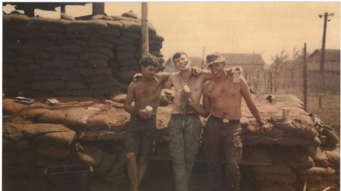 Moore, seen here with friends in Vietnam, had hoped to avoid combat duty by volunteering for the military.