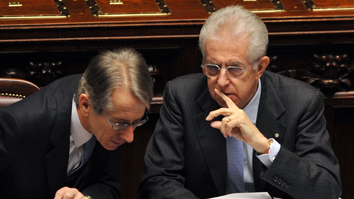 Italian prime minister Mario Monti speaks with his foreign minister before a vote of confidence in Italy's lower house of Parliament.