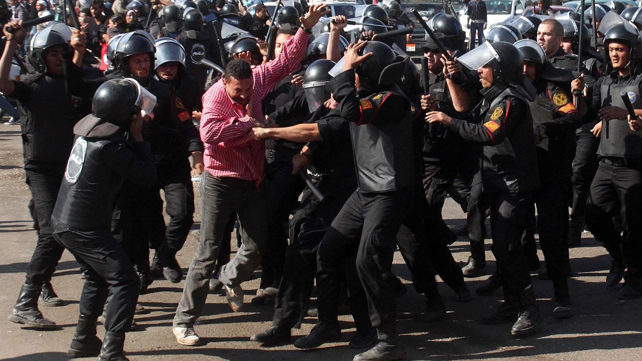 Egyptian riot policemen scuffle with a protester at Cairo's Tahrir Square on Saturday