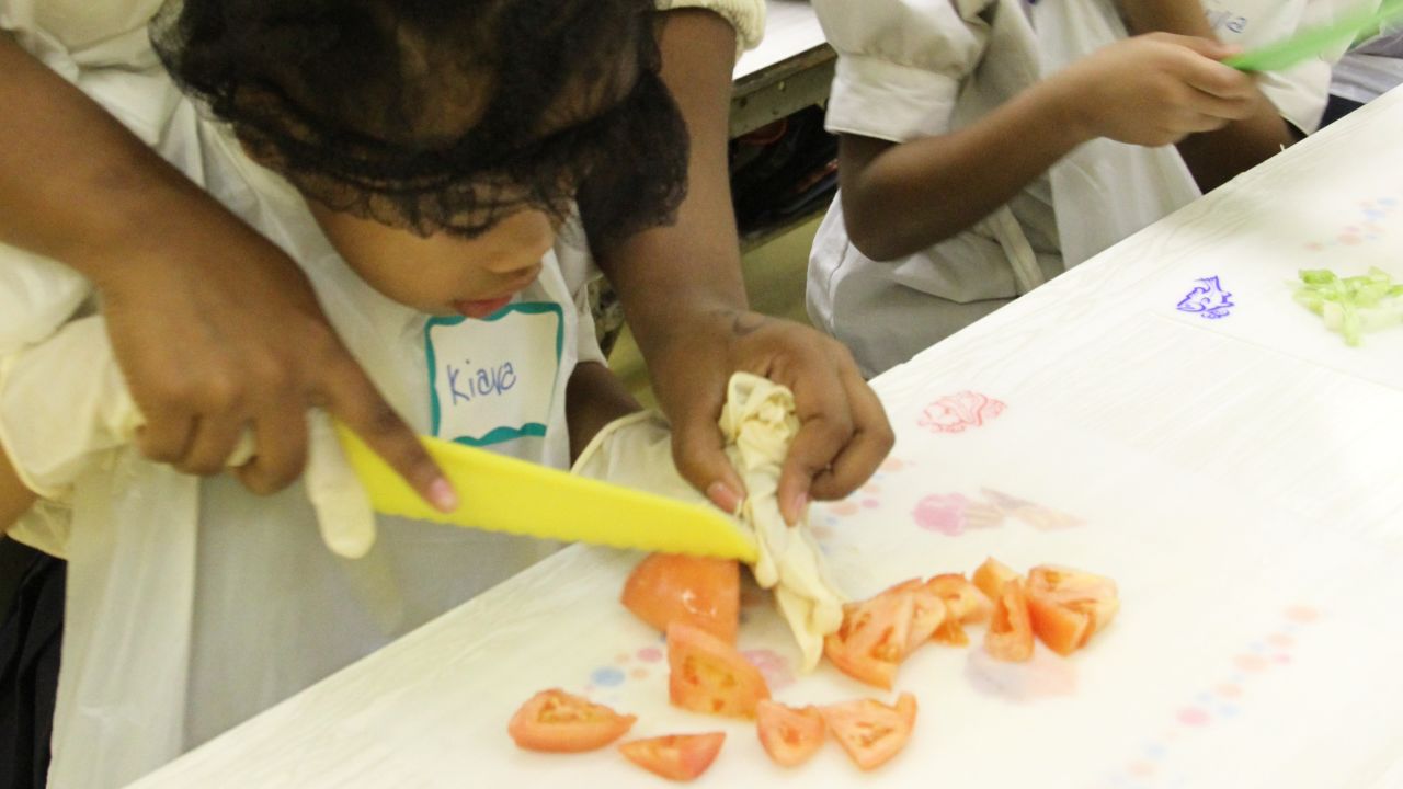 Saprina Gressman helps her daughter Kiara, 4, chop tomatoes in a cooking class in New York. 