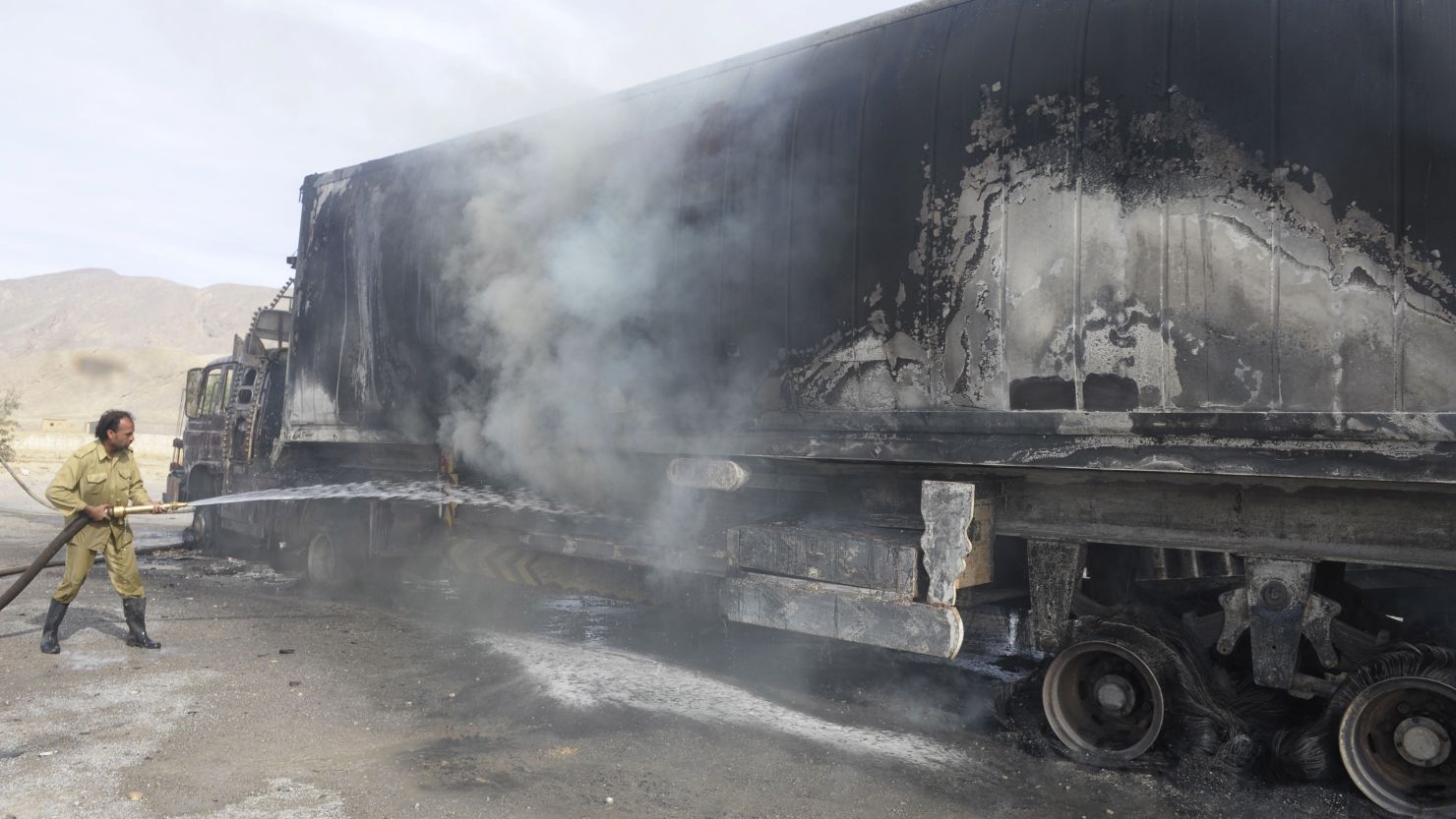 A Pakistani firefighter extinguishes a fire on a burning NATO supply trucks near Quetta on November 20.
