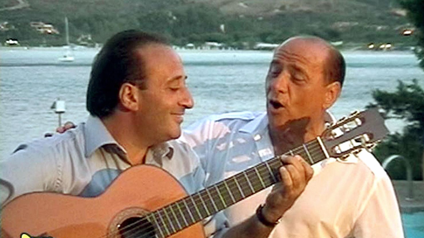 Flamboyant former Italian Prime Minister Silvio Berlusconi sings with guitarist Mariano Apicella during a private party in 2003.