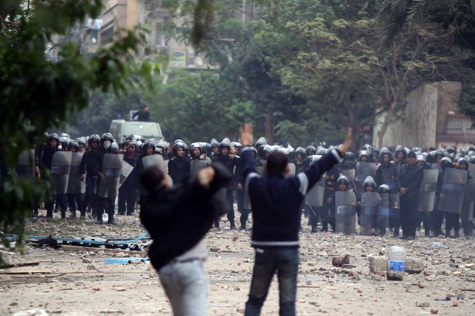 Egyptian protesters hurl rocks at riot police Sunday in Tahrir Square.