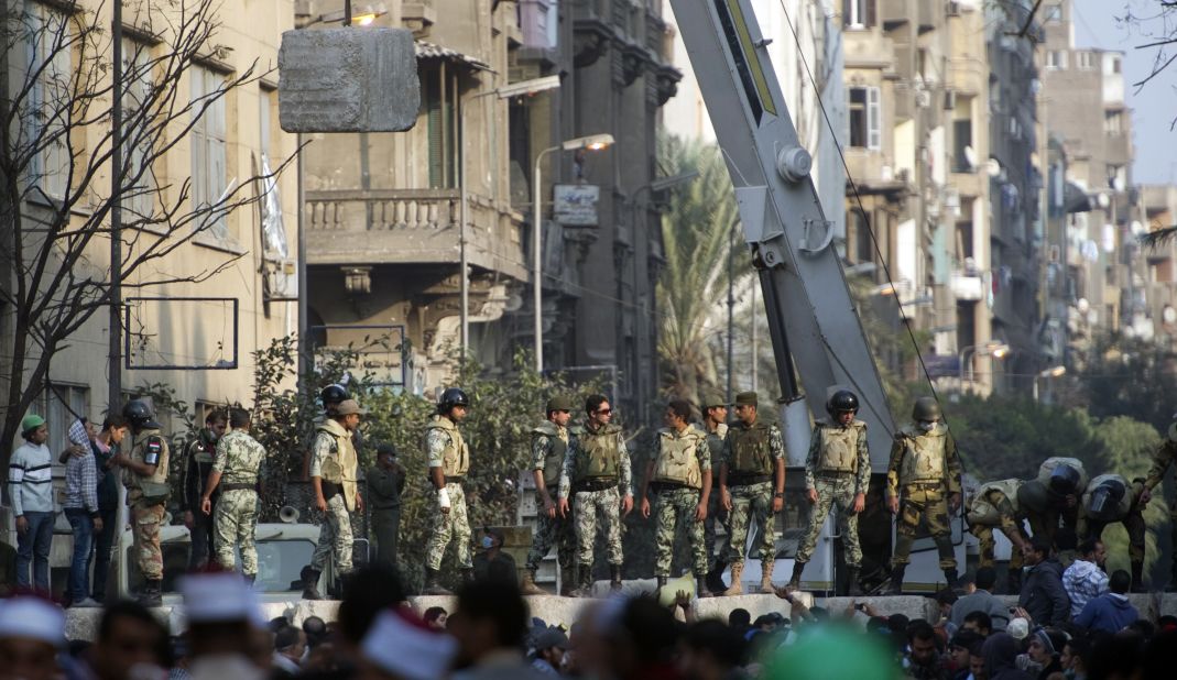 Egyptian military personnel construct a concrete barrier Thursday near Tahrir Square to separate police and protesters. 