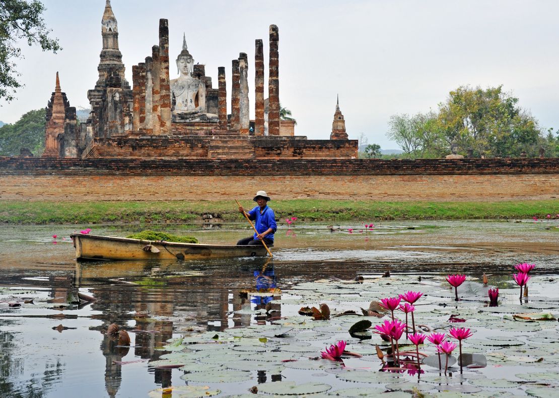 A gardener patrols a Sukhothai moat. 