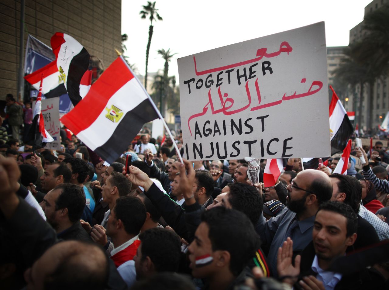 Demonstrators wave flags and signs Friday in Tahrir Square.