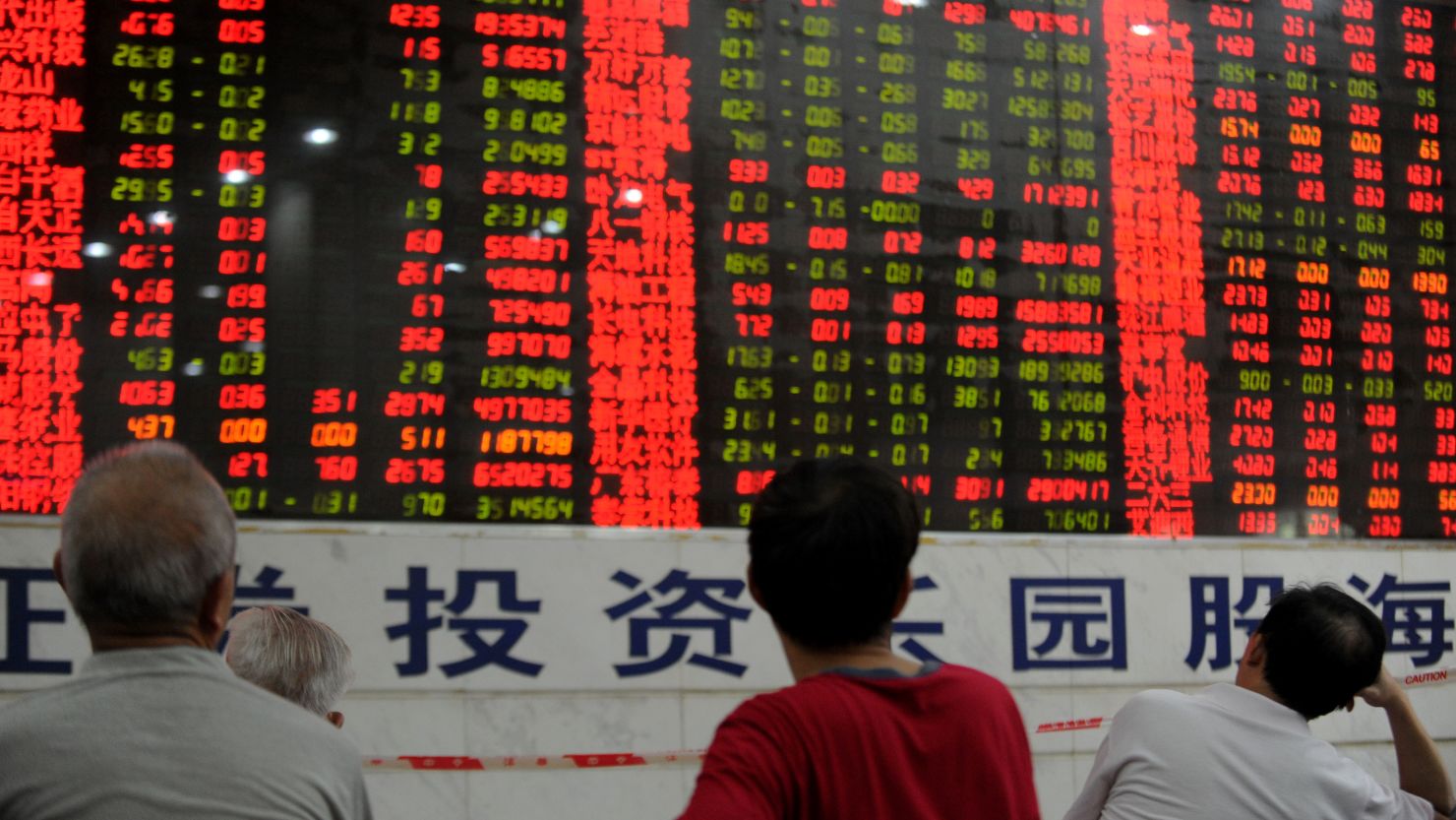 Chinese stock investors check their share prices at a security firm in Wuhan.