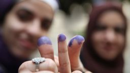 Women show their inked fingers after voting at a polling station in a girls school in Downtown Cairo, Egypt.