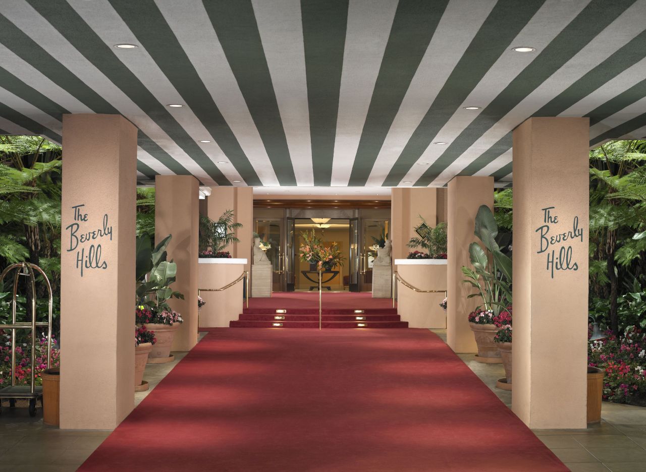 The signature green stripes and red carpet sweep guests into the grand entrance of the Beverly Hills Hotel.