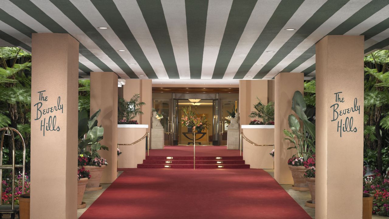 The signature green stripes and red carpet sweep guests into the grand entrance of the Beverly Hills Hotel.