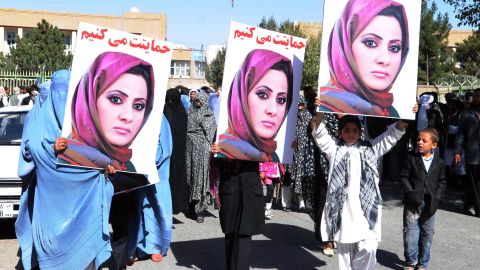 Activists in Herat hold portraits of Semin Barakzai to protest her unseating in the  Afghan parliament over vote-rigging allegations.