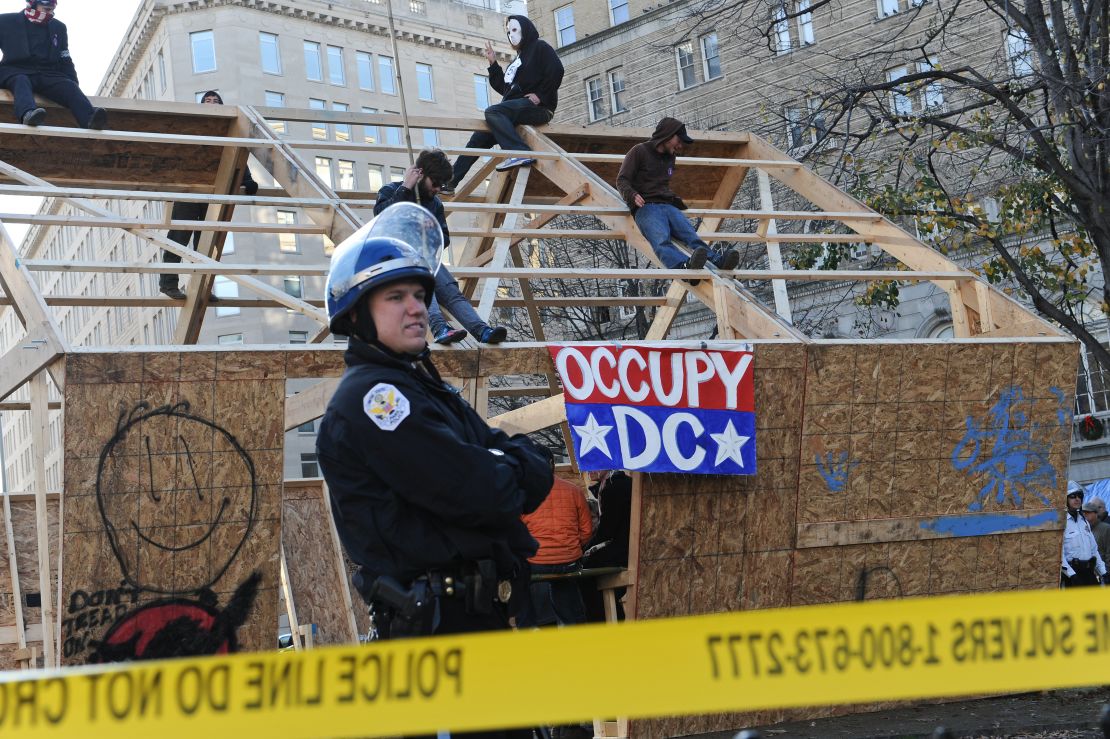 Occupy DC protesters sit atop a wooden structure at their encampment in Washington's McPherson Square on Sunday.