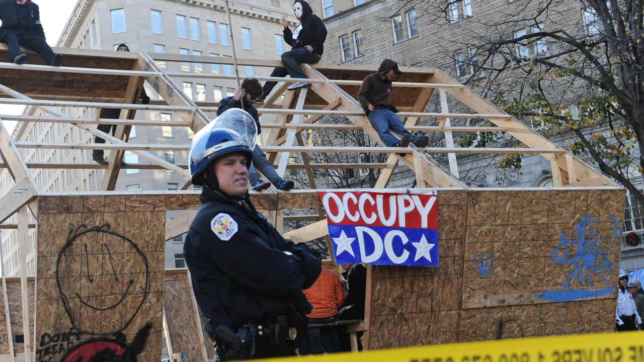 Occupy DC protesters sit atop a wooden structure  at their encampment in Washington's McPherson Square on Sunday.