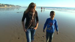 Youssif walks along the California beach with CNN's Arwa Damon, who first told the boy's story in 2007.