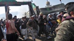 Afghans flee a bomb blast at a shrine in Kabul