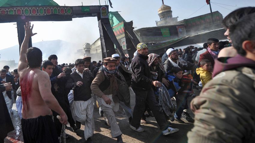 Afghans flee a bomb blast at a shrine in Kabul