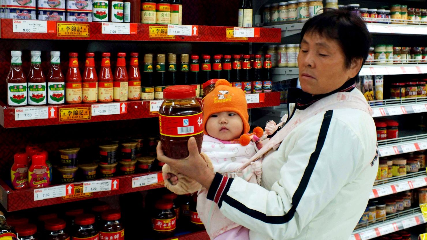	A Chinese woman inspects a bottle of chilli sauce at a supermarket in Yichang, central China's Hubei province on November 9, 2011.