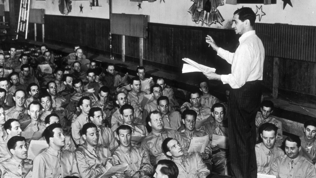 Composer Irving Berlin leads a group of servicemen at Camp Upton in Long Island, New York, in 1942. Berlin wrote "God Bless America."