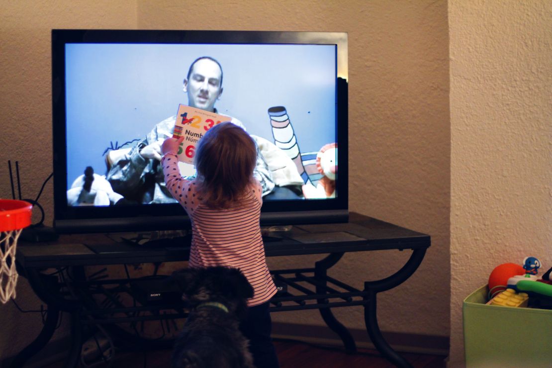Harper holds a book up to the TV as she and her mother, Alexandra, Skype with her father, in November.