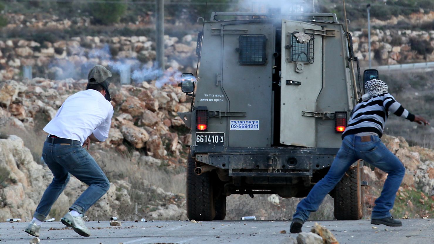 An Active Stills photo shows a tear gas canister being fired by Israeli troops toward Palestinian protester Mustafa Tamimi, left.