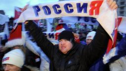 A supporter of Russian prime minister Vladimir Putin holds a scarf with a sign reading 'Russia' as he takes part in a rally.