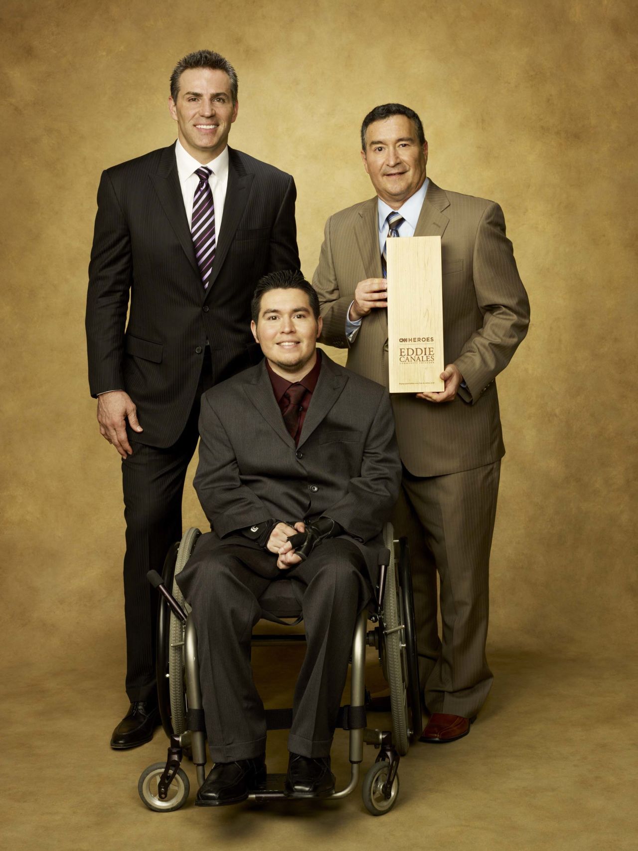 Former NFL quarterback Kurt Warner joins CNN Hero Eddie Canales, founder of "Gridiron Heroes," and his son.