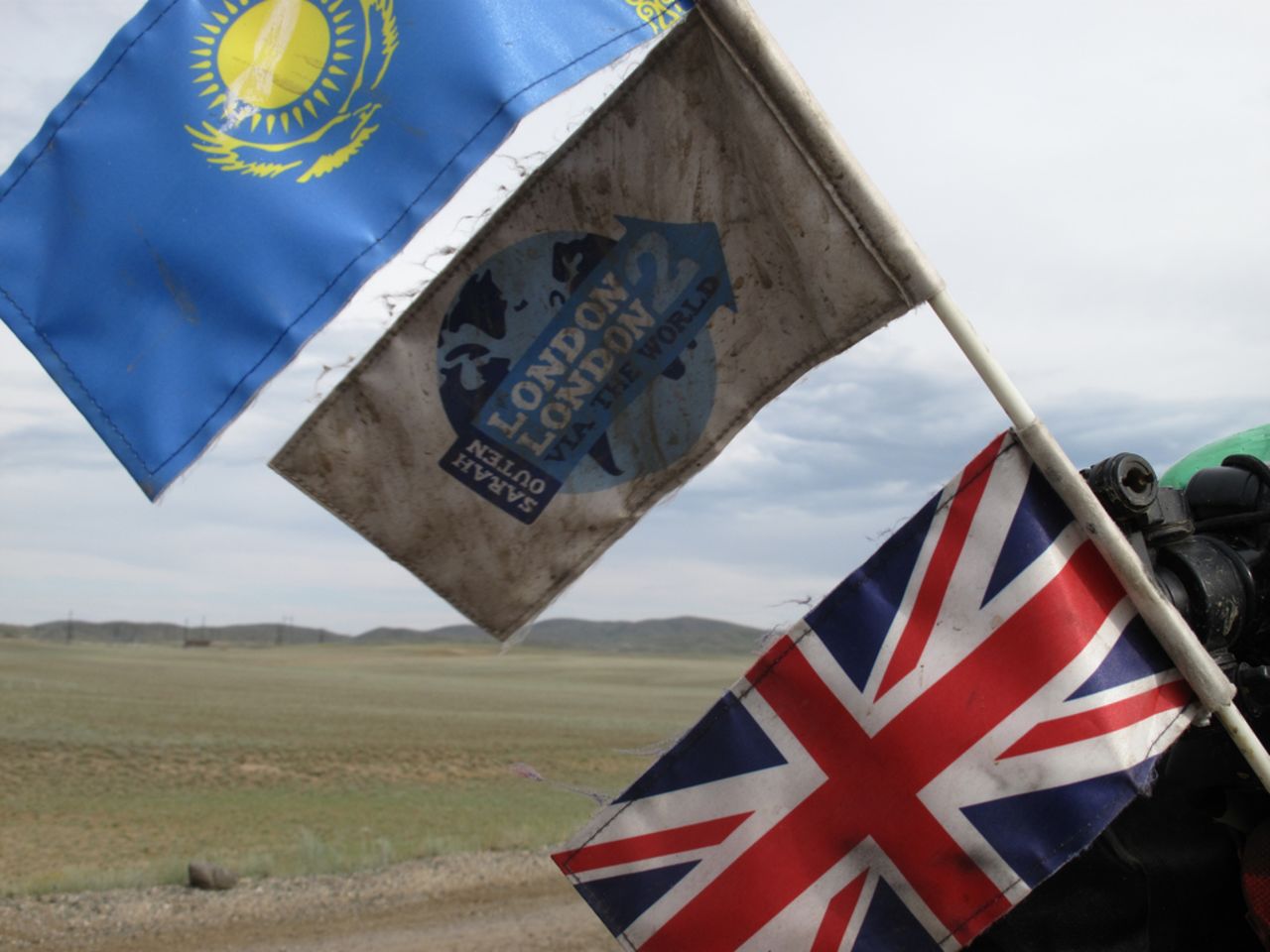 Outen's flags fly high out of her bike kit while cycling into Kazakhstan on May 25, 2011.