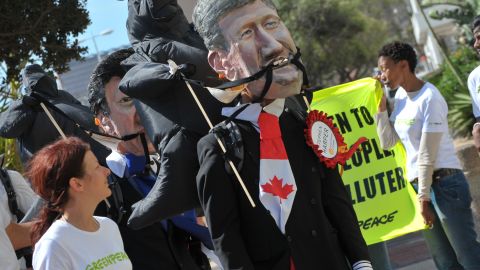 An environmental activist wears a mask depicting Canadian Prime Minister Stephen Harper in Durban, December 5.