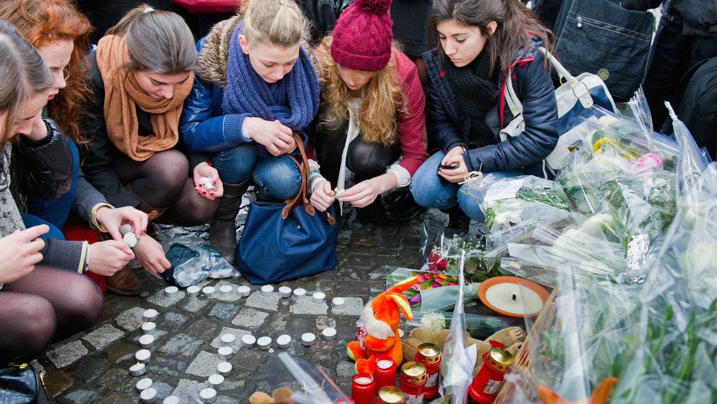 People leave tributes Wednesday at the site of Tuesday's lethal gun and grenade attack in central Liege, Belgium.