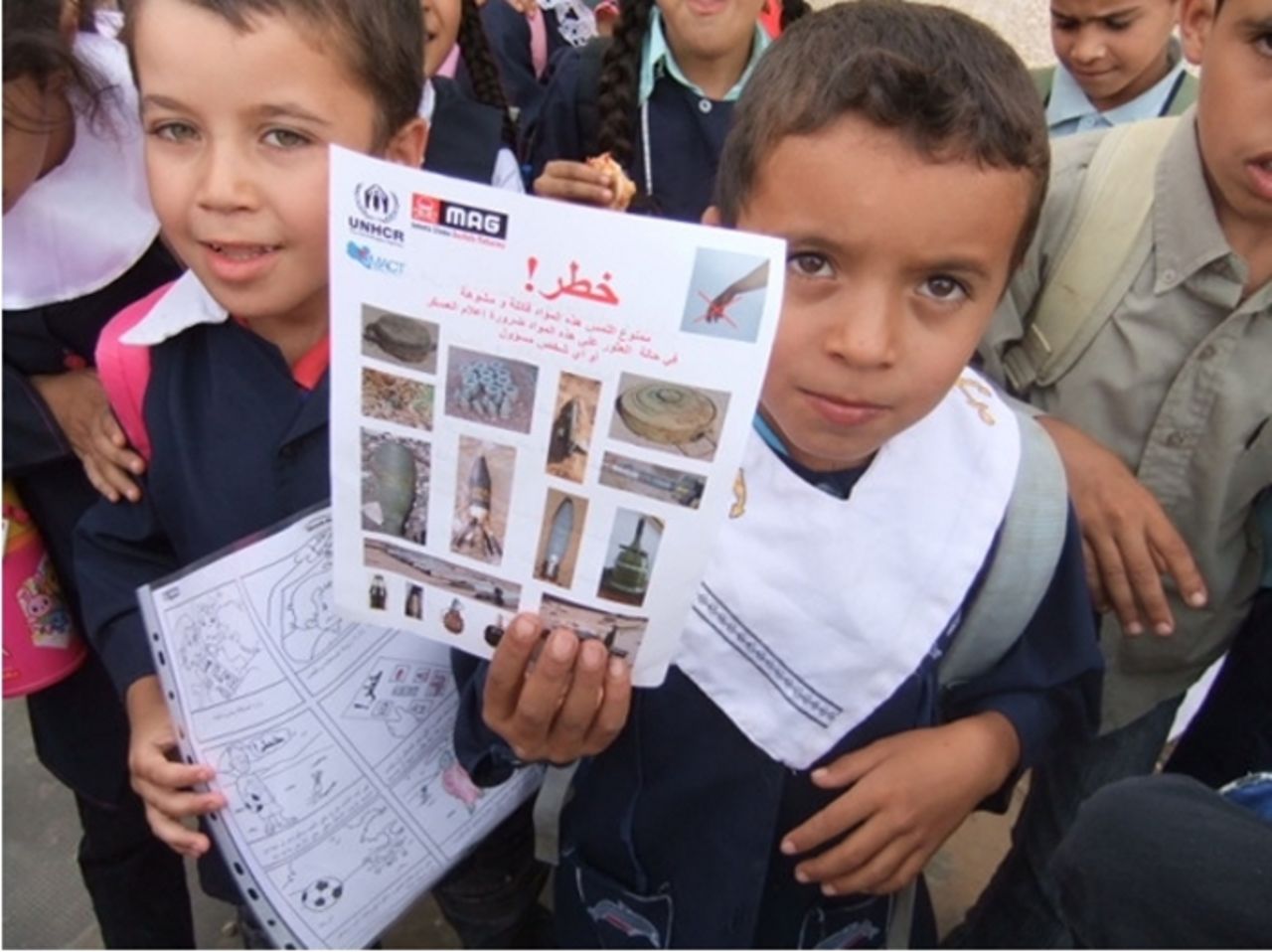 Children show Risk Education posters distributed by Mines Advisory Group in the Nafusa Mountains, Libya.