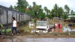 A resident walks past vehicles submerged in floodwaters after tropical storm Washi raked through Iligan City on the soutern island of Mindanao on December 17, 2011. The death toll from tropical storm Washi surged to 180 on December 17 with nearly 400 people missing in flash floods that ravaged the southern Philippines, officials said. AFP PHOTO/Cherryl Vergeire (Photo credit should read CHERRYL VERGEIRE/AFP/Getty Images)