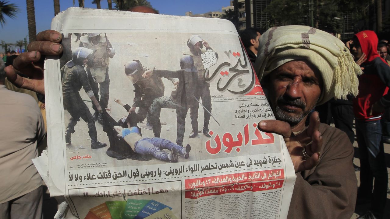A newspaper photo shows Egyptian security forces beating a female demonstrator during clashes in Cairo on Sunday.