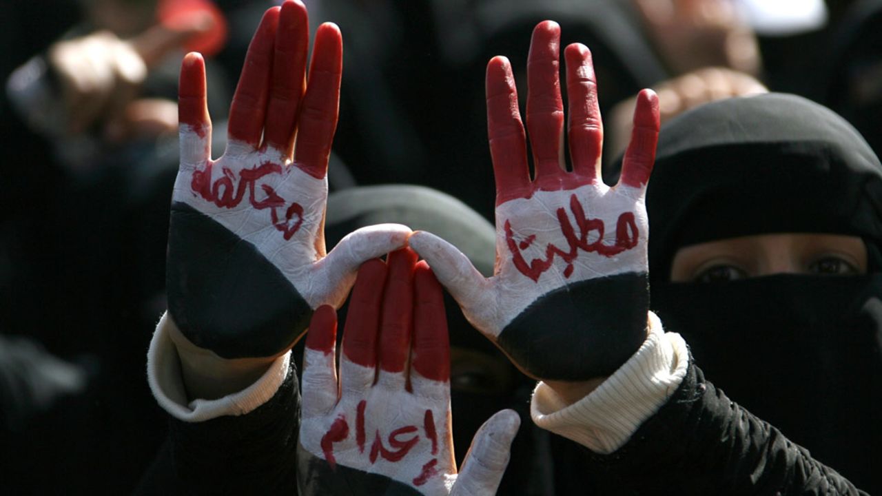 Protesters in Sanaa on December 16, 2011 show the slogans on their palms asking for the trial and execution of President Saleh.