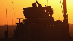 A soldier in the last American military convoy to depart Iraq, from the 3rd Brigade, 1st Cavalry Division, waves after crossing into Kuwait on December 18, 2011.
