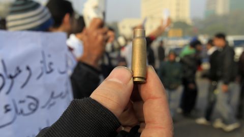 A protester holds up a bullet casing after deadly clashes with the military in Tahrir Sqaure