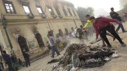 Protesters gather debris near the Institute of Egypt, which was torched during protests, in Cairo on December 20.