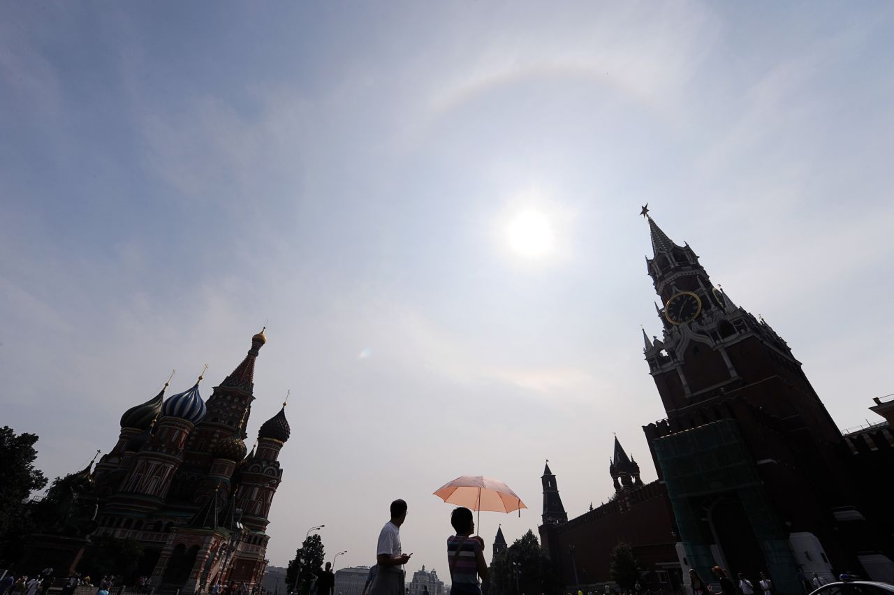 Russians walk near the Kremlin on Red Square under clear blue skies during a rare heat wave in Moscow, in August, 2010.  According to a new report from the UK's Met Office, man-made climate change is likely to cause a global temperature rise of around 3-5C over the next century, and significantly increase instances of freak weather events.  