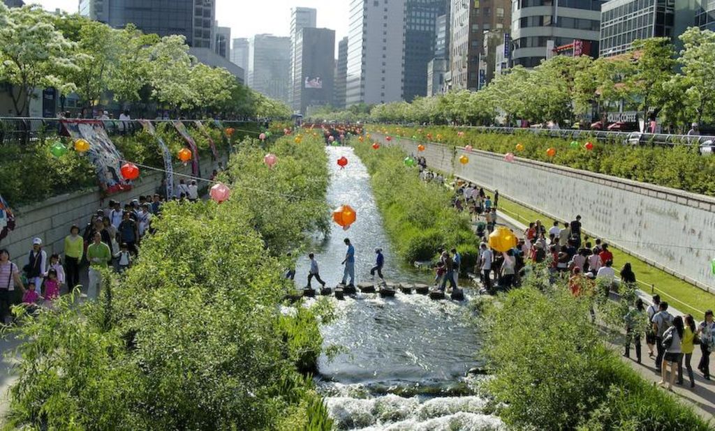 A newly restored stream flows through high-rise buildings in the center of Seoul in September 2005. The city revived the 5.8 kilometer (3.5 mile) stretch of the stream, which was buried under concrete for decades during South Korea's headlong scramble for economic development. Simon Reddy from the C40 Cities network says the river will help create a "wind corridor" to keep the city cool as temperatures rise.