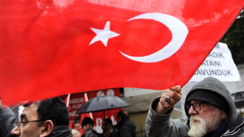 A man waves a Turkish flag as he takes part in a rally in front of the French Consulate in Istanbul on December 22.