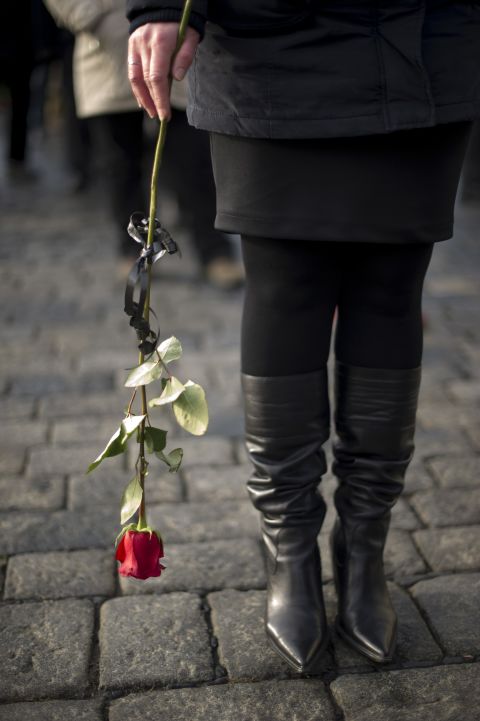 A woman in line holds a rose as she waits to pay respects to Havel on Thursday, December 22.
