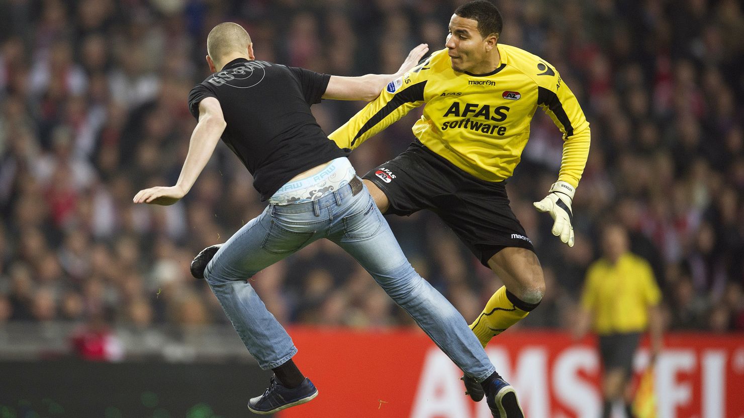 AZ Alkmaar goalkeeper Esteban kicks a man who attacked him from behind during the Dutch Cup match at Ajax.