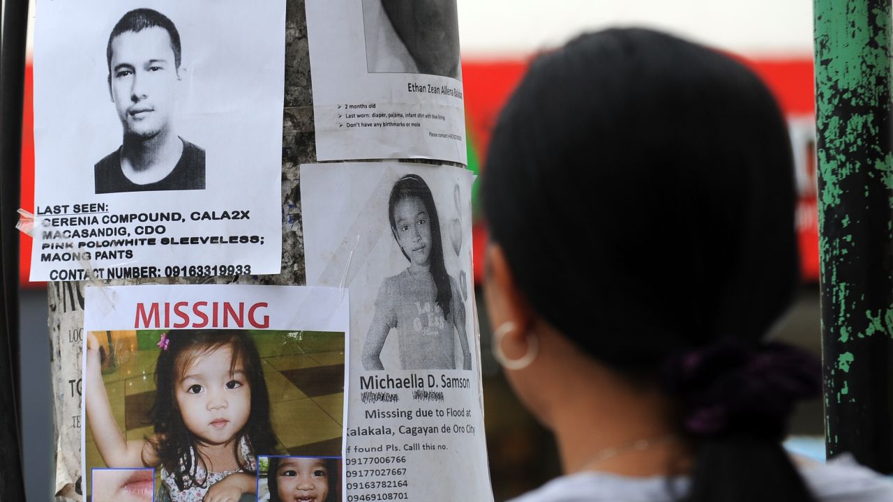A woman looks at posters of missing persons in Cagayan de Oro City in Mindanao on December 22, 2011. 