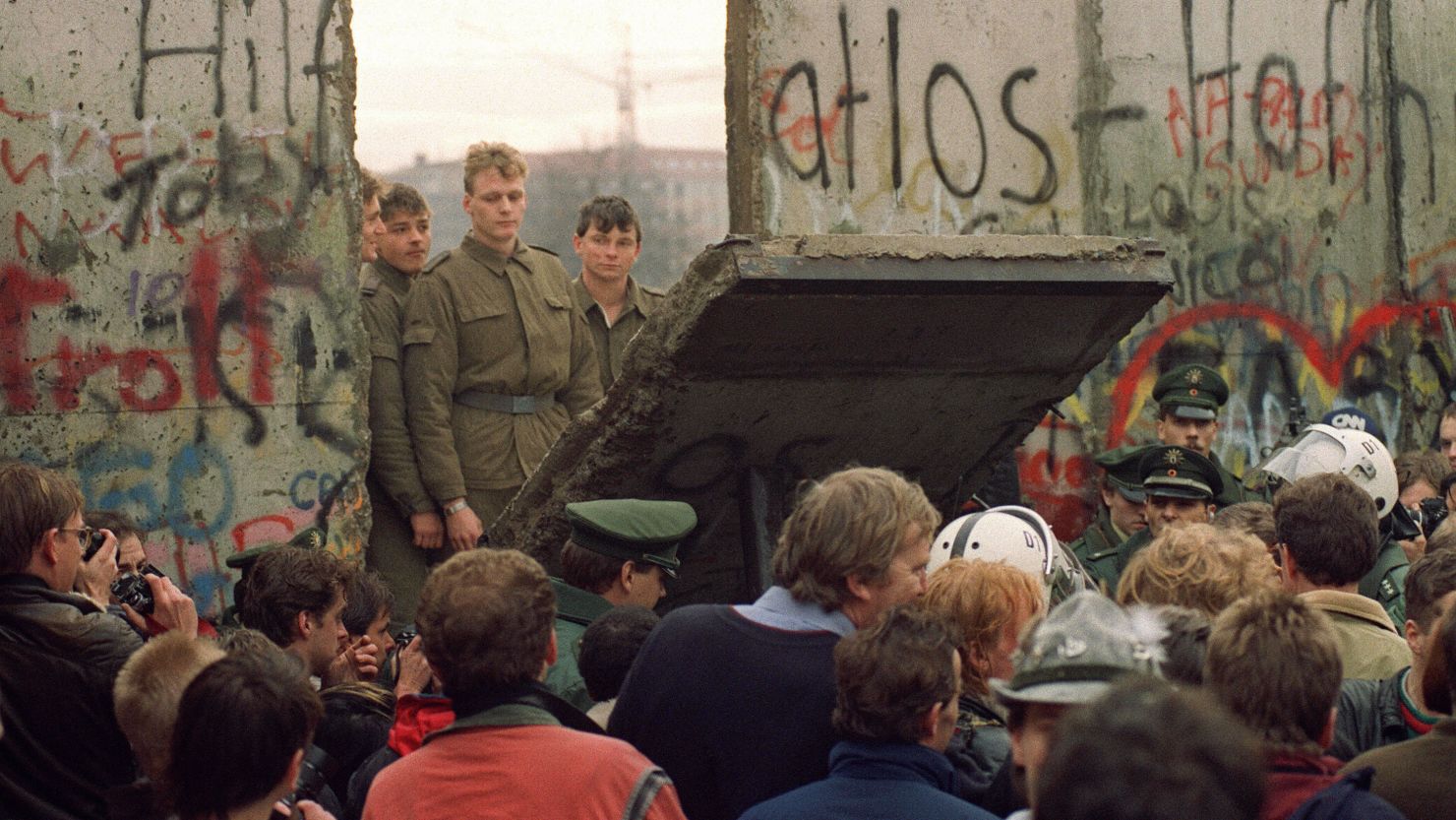 West Berliners at the Berlin Wall on November 11, 1989 watch as East German border guards open a new crossing.
