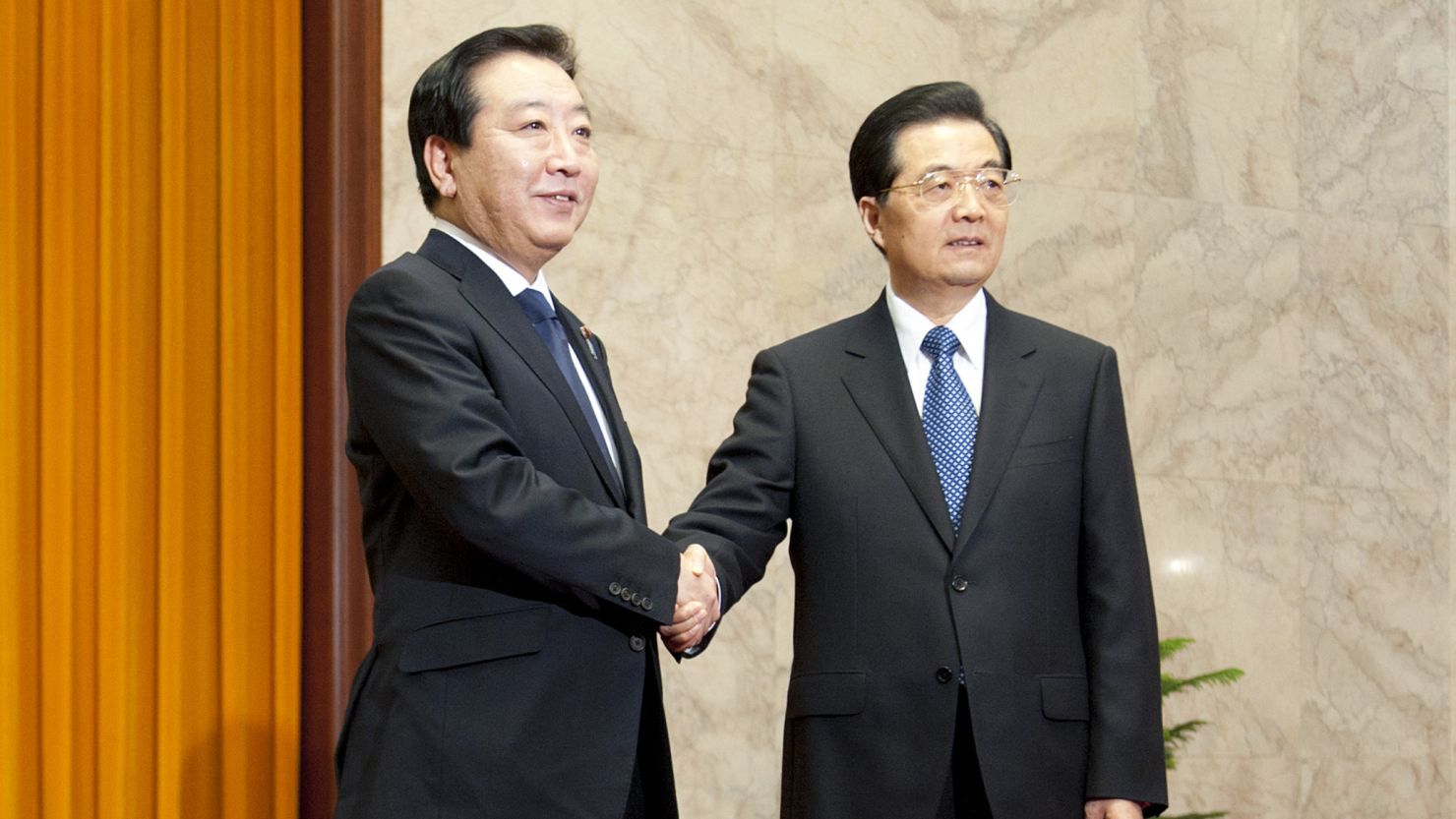 Japan's Prime Minister Yoshihiko Noda, left, shakes hands with China's President Hu Jintao in Beijing on Monday.