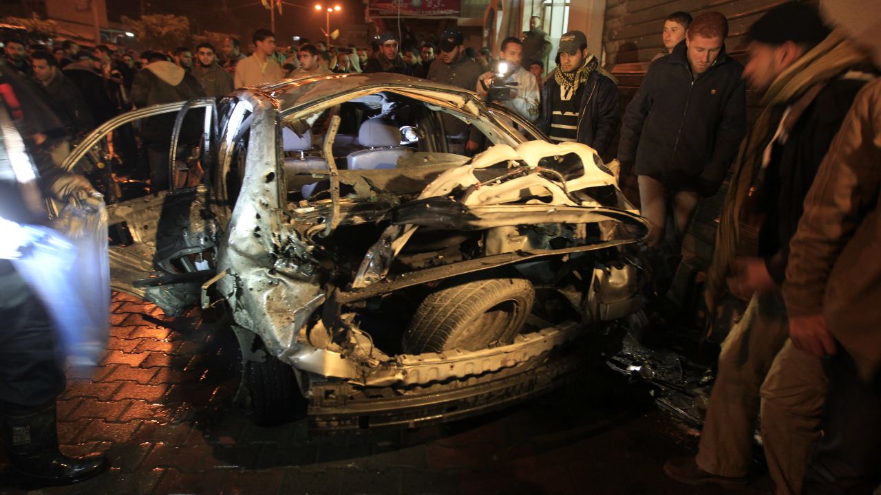 Palestinians look at a damaged car in Beit Lahia in the northern Gaza Strip after an Israeli airstrike on Tuesday.