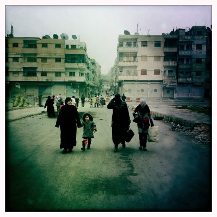 Despite the threat from snipers, a family makes its way down Cairo Street in Al Khaledia in Homs, Syria.