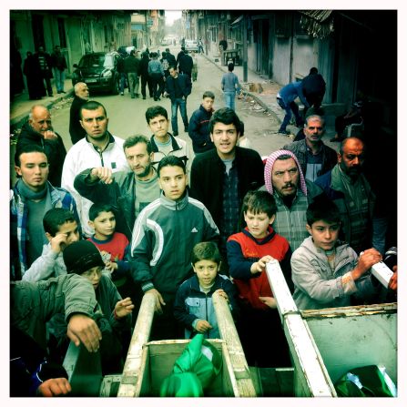 Residents from the Al Khaledia suburb surround a coffin in Khaledia, Homs.