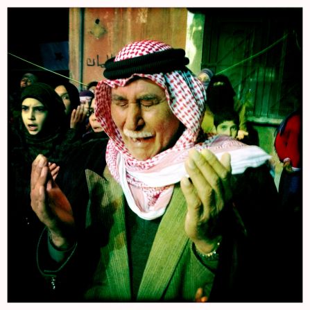 An old man prays at a night demonstration in the Al Khaledia neighborhood in Homs, Syria