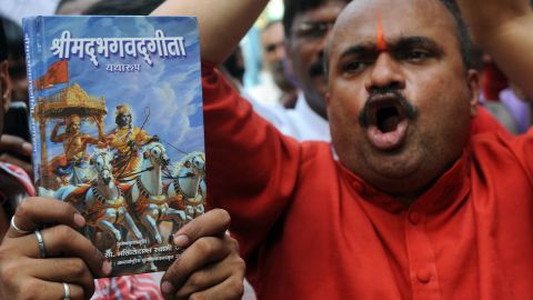 Protesters hold a copy of the Bhagavad Gita during a rally outside the Russian consulate in Mumbai on December 21, 2011. 